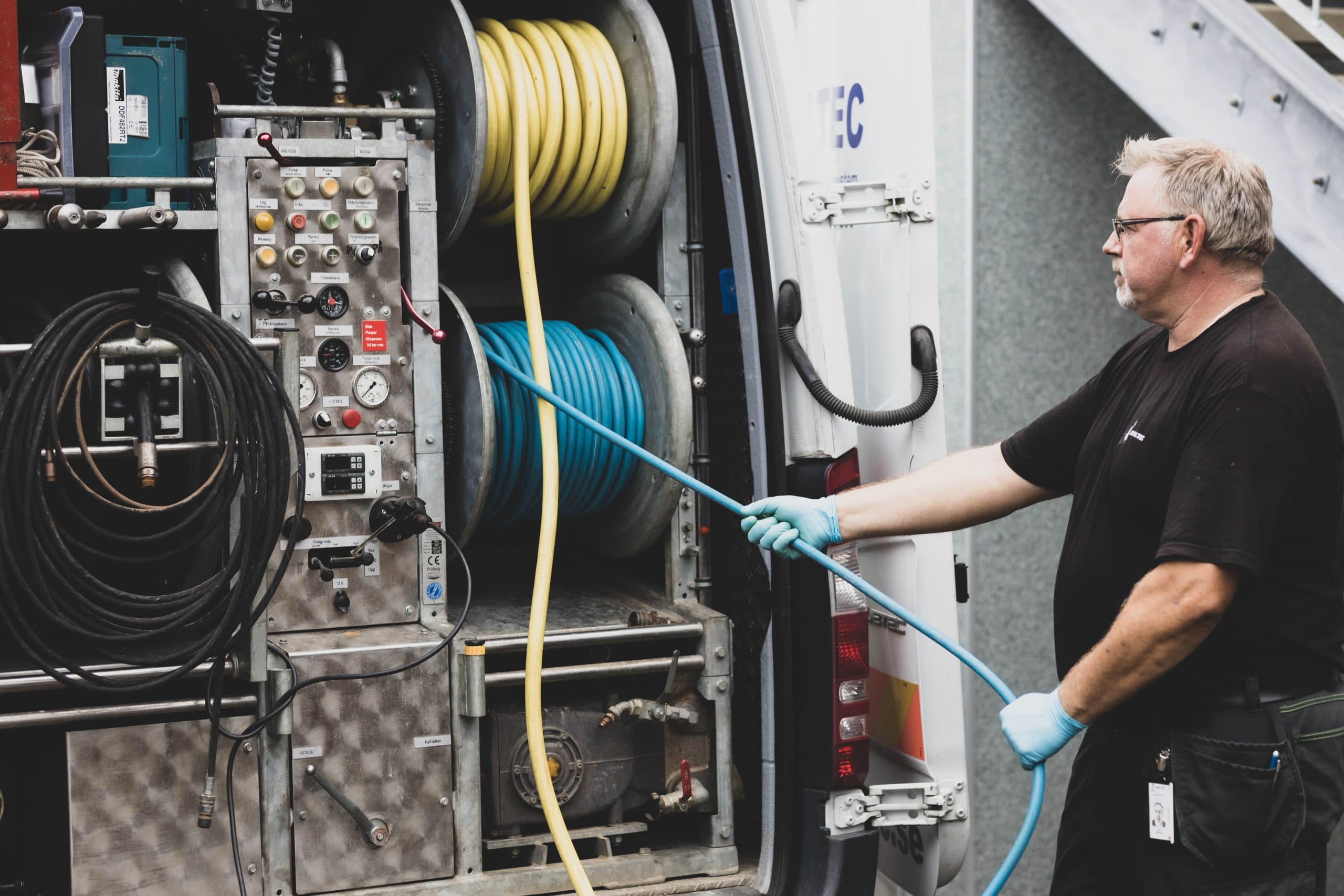 En man som drar en slang - Spoltec serviceavtal